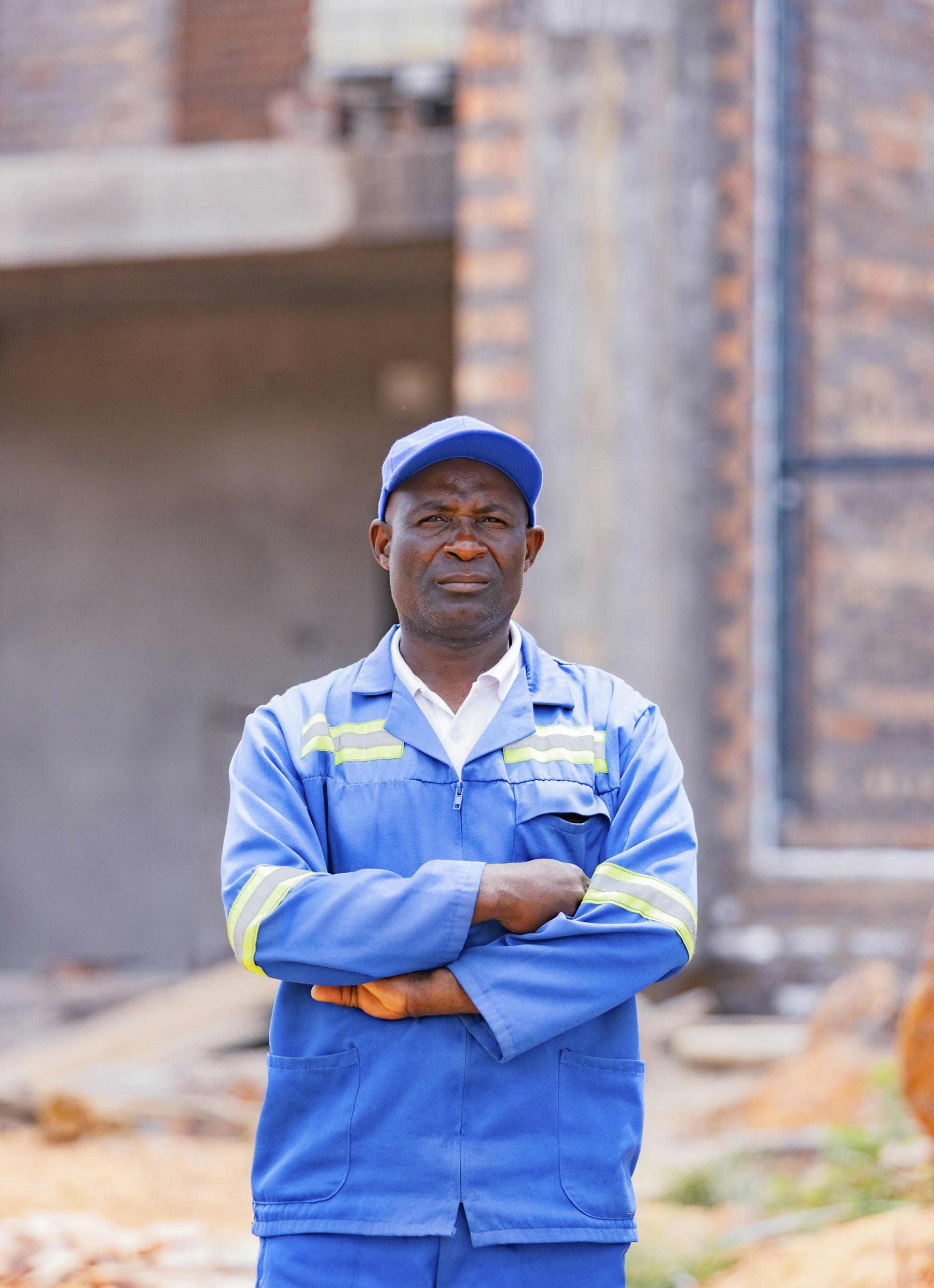 Tradesperson standing with arms folded on a work site